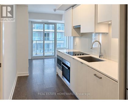 A modern kitchen with white cabinets and a stainless steel sink.