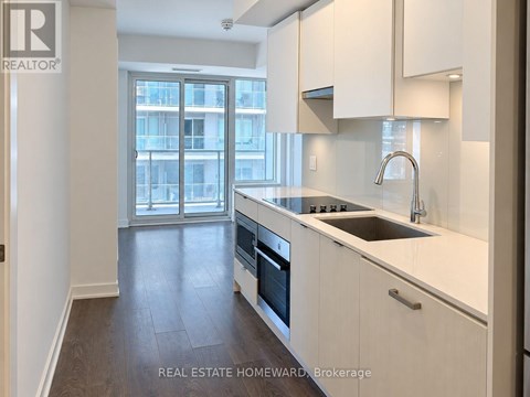 A modern kitchen with white cabinets and a stainless steel sink.
