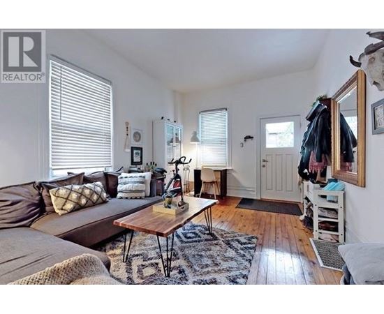 A living room with a brown couch and a wooden coffee table.