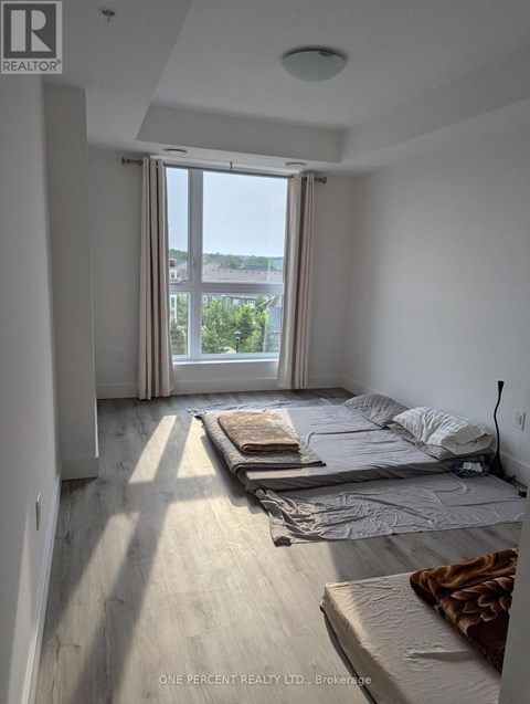 A bedroom with a bed, mattresses, and a window overlooking a cityscape.