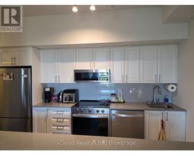 A kitchen with white cabinets and stainless steel appliances.