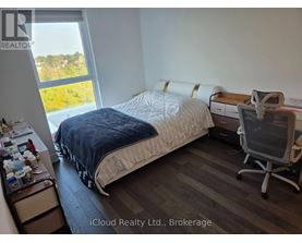 A bedroom with a bed, desk, and chair.