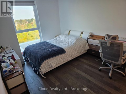 A bedroom with a bed, desk, and chair.