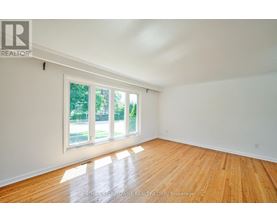 A room with wooden floors and a large window.