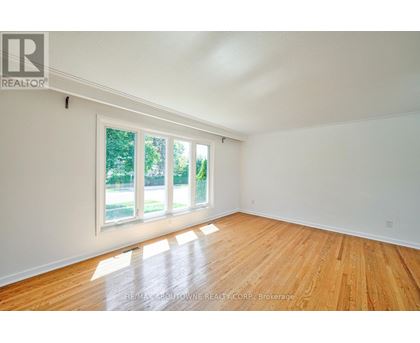 A room with wooden floors and a large window.