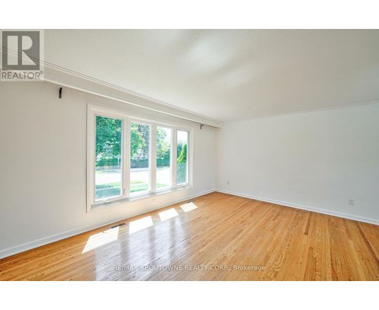 A room with wooden floors and a large window.
