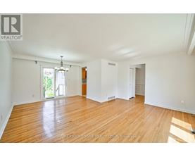 A large empty room with wooden floors and white walls.