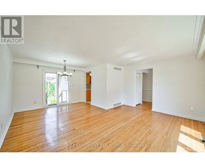 A large empty room with wooden floors and white walls.