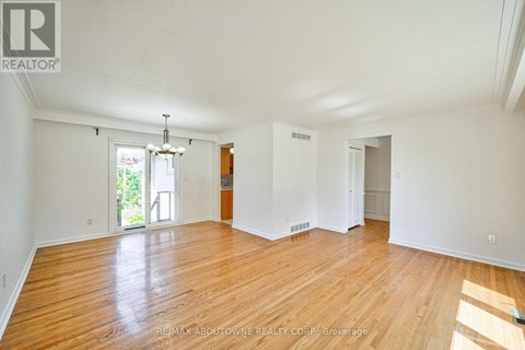A large empty room with wooden floors and white walls.