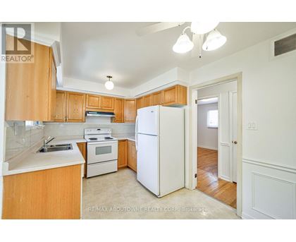 A kitchen with wooden cabinets and white appliances.