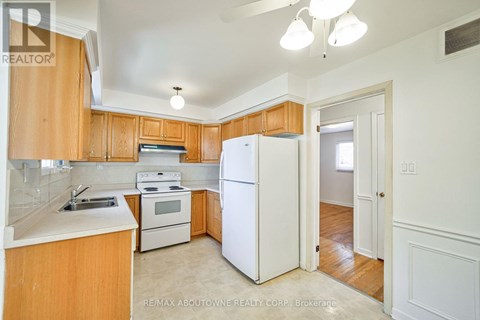 A kitchen with wooden cabinets and white appliances.
