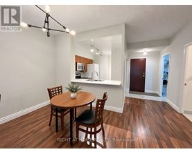 A dining room with a wooden table and chairs.