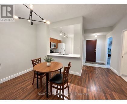 A dining room with a wooden table and chairs.