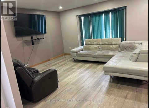A living room with a white couch and a black leather chair.