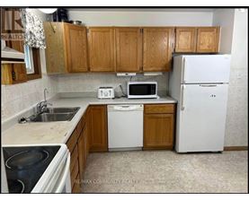A kitchen with wooden cabinets and white appliances.