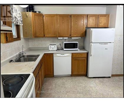 A kitchen with wooden cabinets and white appliances.