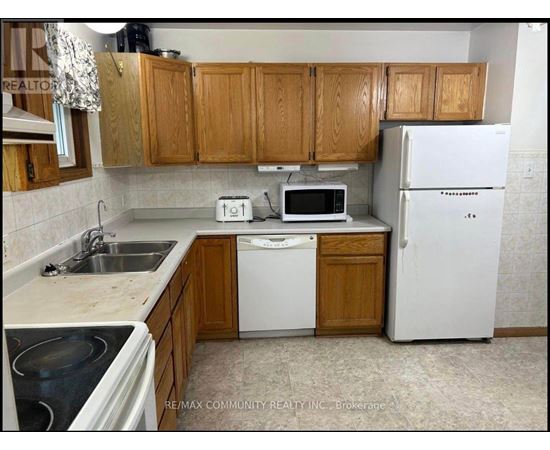 A kitchen with wooden cabinets and white appliances.
