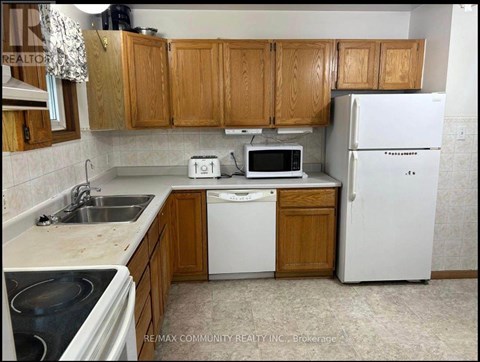 A kitchen with wooden cabinets and white appliances.