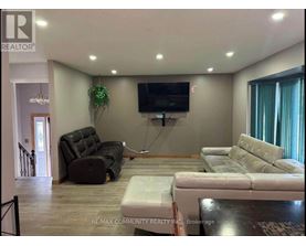 A living room with a couch, chair, and television.