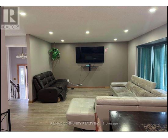 A living room with a couch, chair, and television.