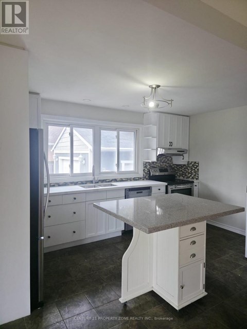 A kitchen with white cabinets and a granite countertop.