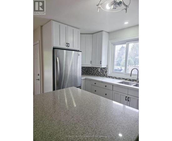 A kitchen with granite countertops and white cabinets.