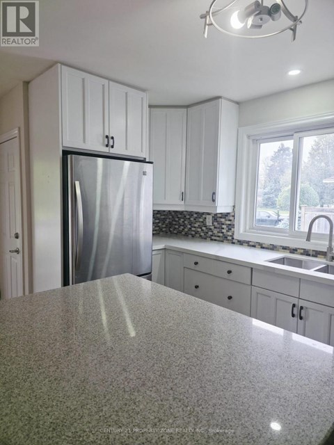 A kitchen with granite countertops and white cabinets.