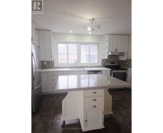 A kitchen with white cabinets and a marble countertop.