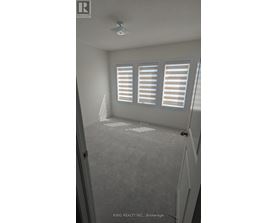 A room with a carpeted floor and a window with blinds.