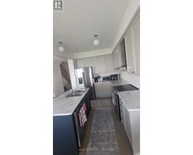 A kitchen with white cabinets and a marble countertop.
