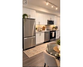 A modern kitchen with a glass table and stainless steel appliances.