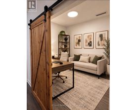 A room with a wooden door, a couch, a desk, and some plants.