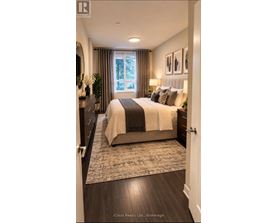 A bedroom with a large bed and a window with curtains.