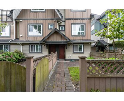 A house with a brown fence and a brick pathway leading to the front door.