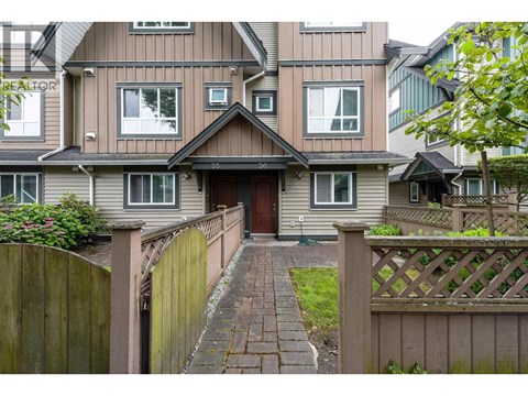 A house with a brown fence and a brick pathway leading to the front door.