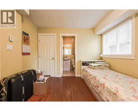 A bedroom with a bed, dresser, and suitcases.