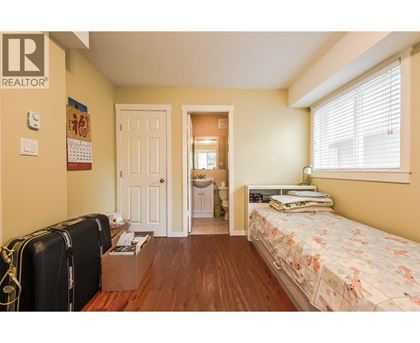 A bedroom with a bed, dresser, and suitcases.