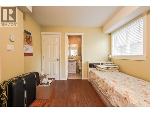 A bedroom with a bed, dresser, and suitcases.