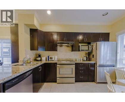 A kitchen with a black dishwasher and stove top oven.