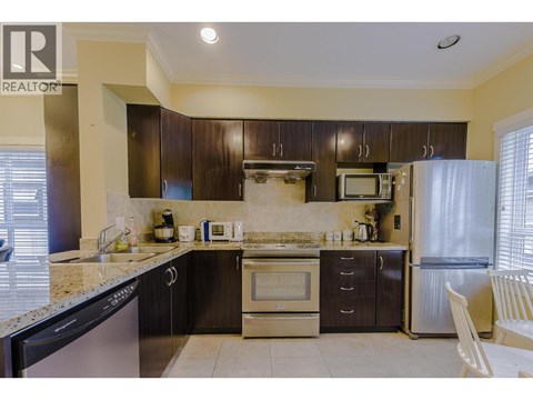 A kitchen with a black dishwasher and stove top oven.