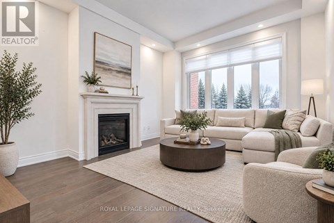 A living room with a fireplace and a painting on the wall.