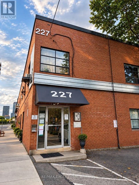 The building number 227 is a red brick building with a black awning.