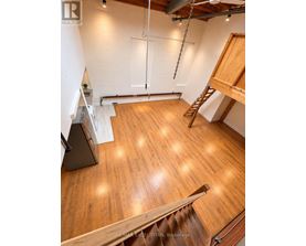 A room with wooden floors and a ladder.