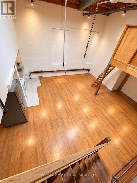 A room with wooden floors and a ladder.