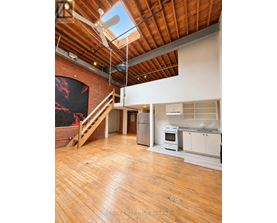 A large open space with wooden floors and a skylight.