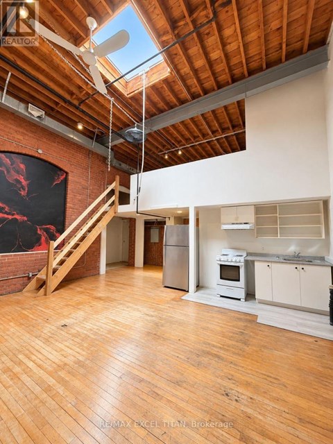 A large open space with wooden floors and a skylight.