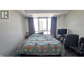 A bedroom with a large bed and a flat screen TV.