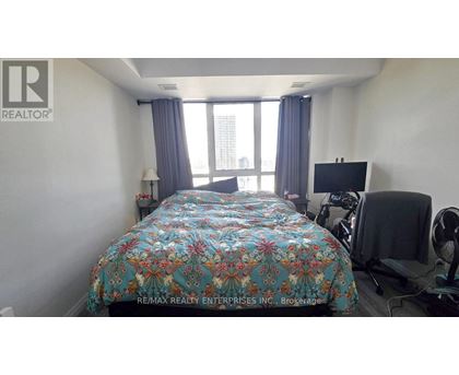 A bedroom with a large bed and a flat screen TV.