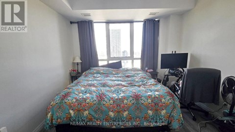A bedroom with a large bed and a flat screen TV.