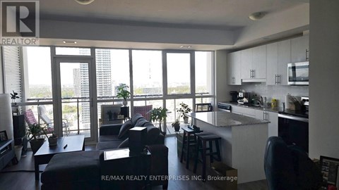 A modern kitchen with a bar stool and a view of the city.